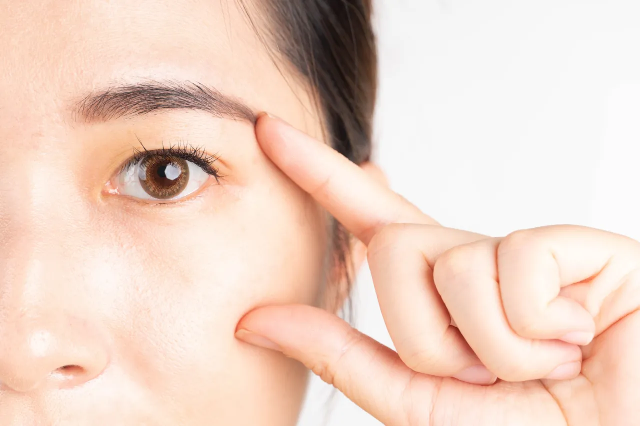 Woman gently touching her eyelid